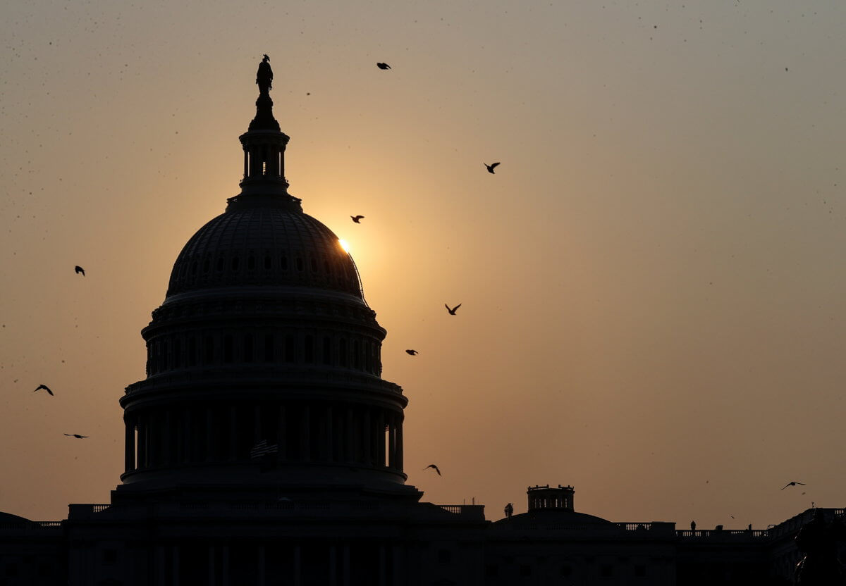 The sun rises behind the U.S. Capitol in Washington
