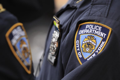 New York Police Department officers stand outside of a midtown Manhattan office building after evacuating workers that had been overcome by fumes in New York
