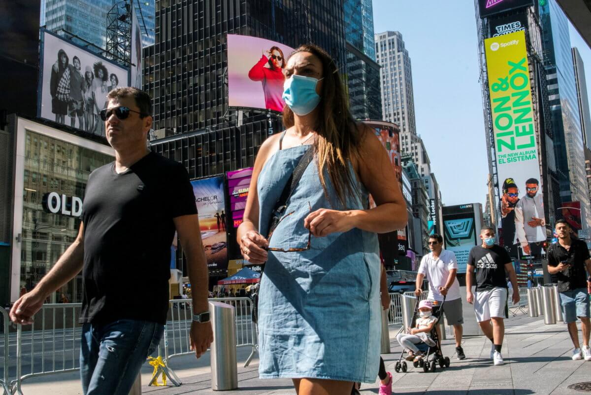 People wear masks around Times Square, as cases of the infectious coronavirus Delta variant continue to rise in New York City, New York
