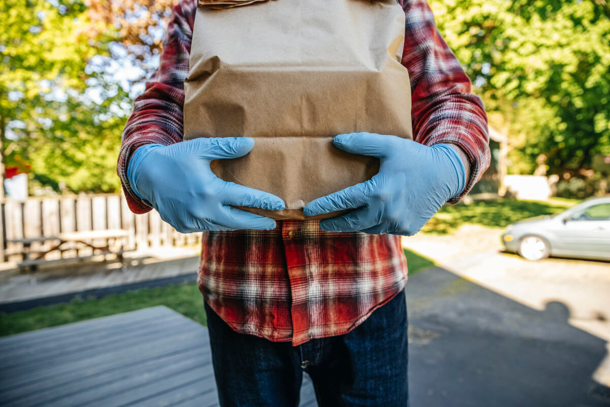 Man holding a package with gloves on