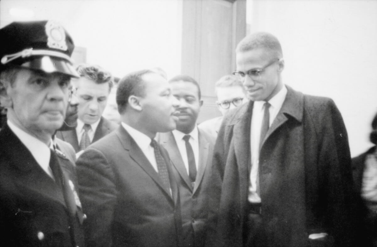 FILE PHOTO: Martin Luther King Jr. and Malcolm X wait for a press conference to begin in an unknown location