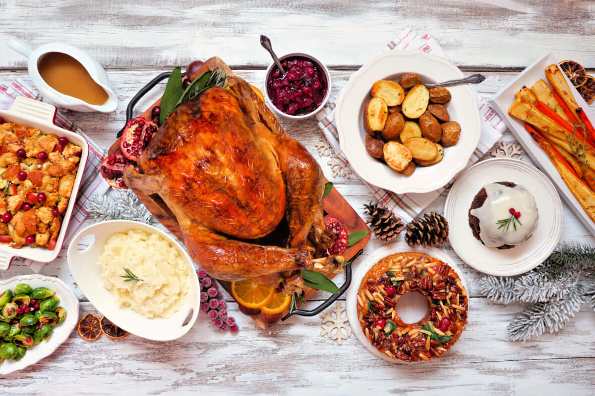Traditional Christmas turkey dinner. Above view table scene on a rustic white wood background.