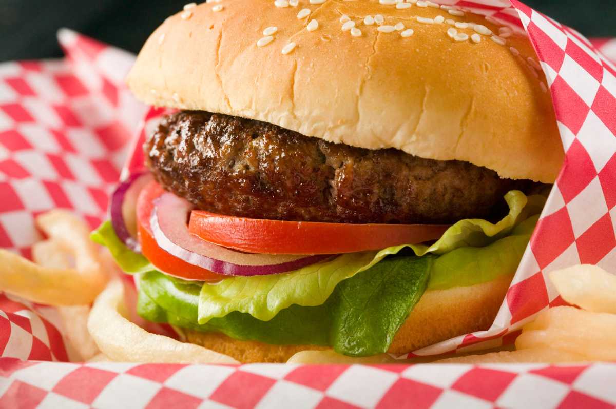 Hamburger with lettuce, tomato, red onion and French fries