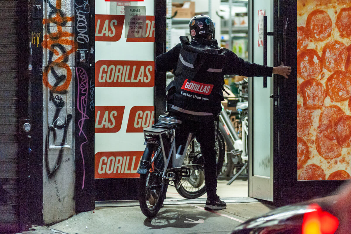 gorillas delivery worker riding a bike into warehouse