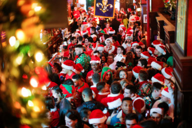 Revelers dressed as Santa Claus share drinks in a local bar as they take part in the event called SantaCon in New York