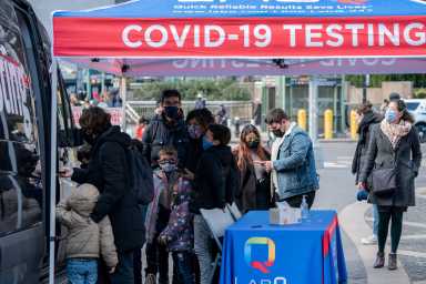 FILE PHOTO: People queue at a popup COVID-19 testing site in New York
