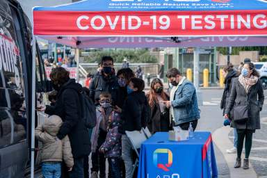 FILE PHOTO: People queue at a popup COVID-19 testing site in New York