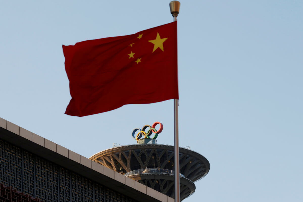 FILE PHOTO: Chinese flag flutters near the Olympic rings on the Olympic Tower in Beijing