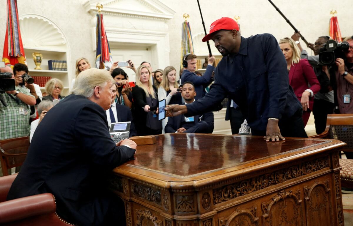 FILE PHOTO: Rapper Kanye West shows President Trump his mobile phone during meeting in the Oval Office at the White House in Washington