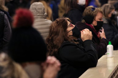 People in face masks pray following a catholic mass at St. Patrick’s Cathedral ahead of Christmas as the Omicron coronavirus variant continues to spread in Manhattan, New York City