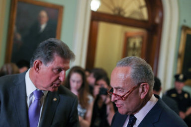 U.S. Senate Minority Leader Schumer and Senator Manchin confer before addressing reporters at the U.S. Capitol in Washington