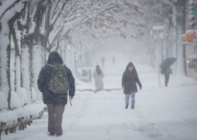 People make their way through the snow during a snow storm in Brooklyn, New York