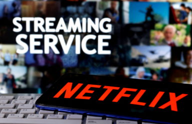 FILE PHOTO: A smartphone with the Netflix logo is seen on a keyboard in front of displayed “Streaming service” words in this illustration