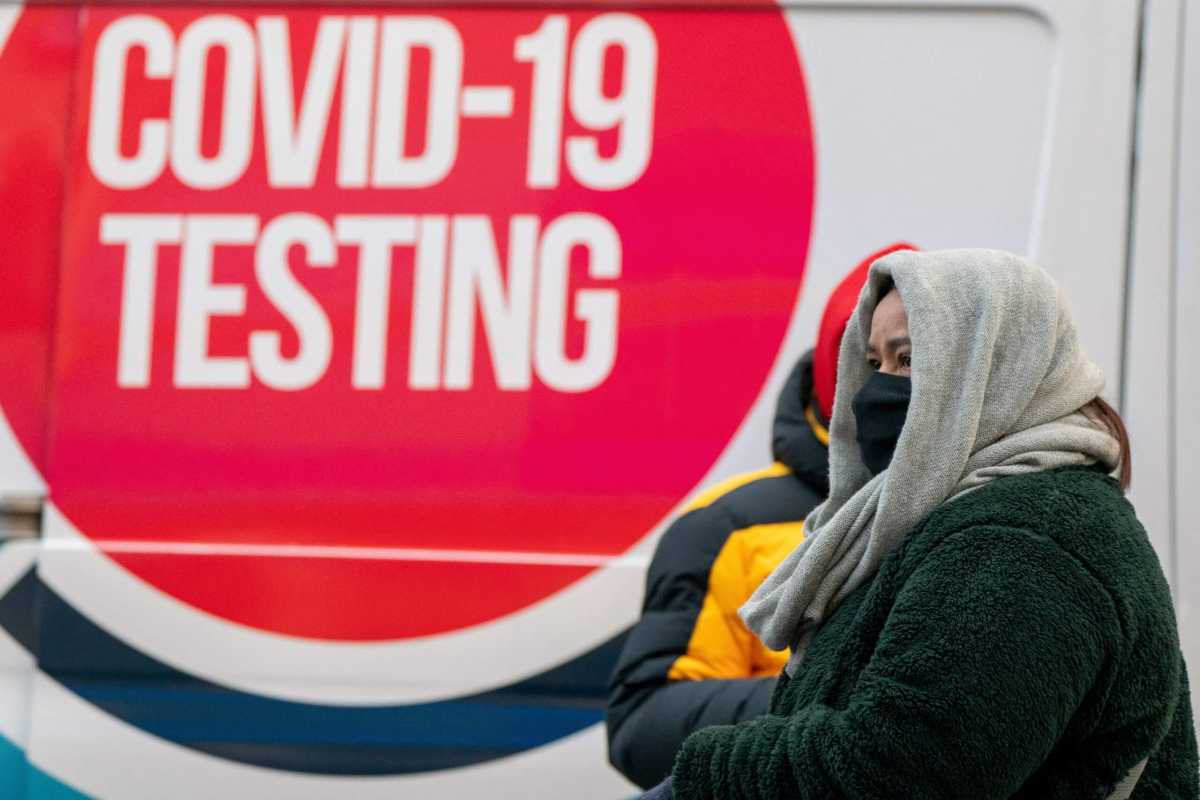 People brace against the cold while waiting for COVID-19 to be administered