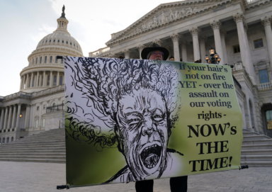 A voting rights demonstrator holds a banner in front of the U.S. Capitol in Washington