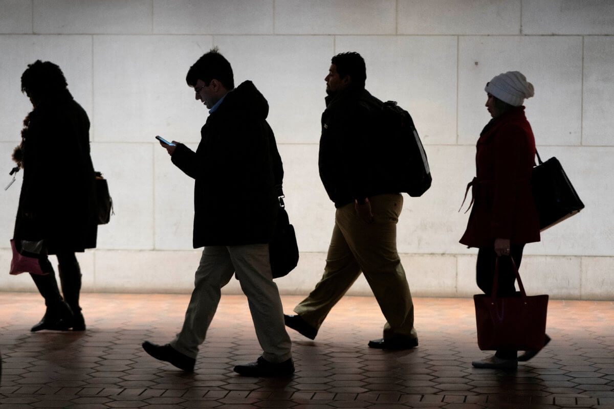 FILE PHOTO: Commuters walk from Metro station after U.S. government reopened after 35-day shutdown in Washington