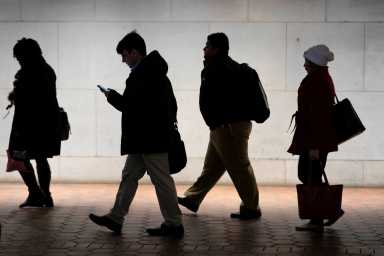 FILE PHOTO: Commuters walk from Metro station after U.S. government reopened after 35-day shutdown in Washington