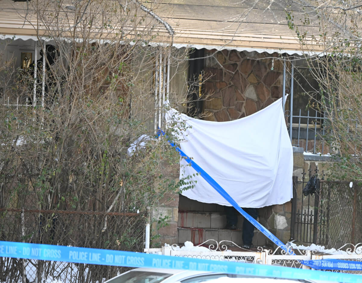 A white sheet covers the body of a shooting victim at 568 Empire Blvd.