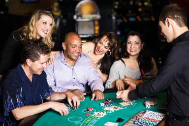 Diverse Group of People Playing Blackjack In a Casino