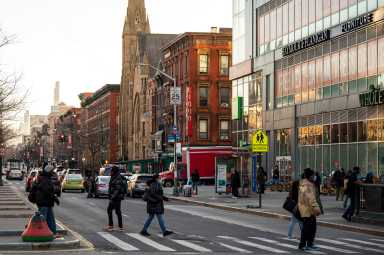 Pedestrians cross 125th Street in Harlem