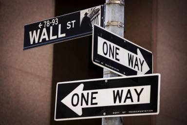 FILE PHOTO: A ‘Wall St’ sign is seen above two ‘One Way’ signs in New York