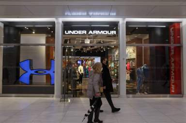 FILE PHOTO – People walk by an Under Armour store in Manhattan, New York City