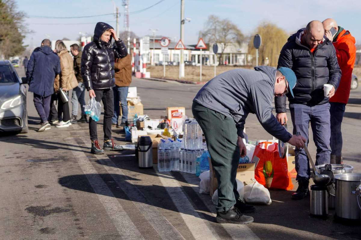 Romanians serve tea, water and food to people crossing the border from Ukraine into Romania at Siret Customs