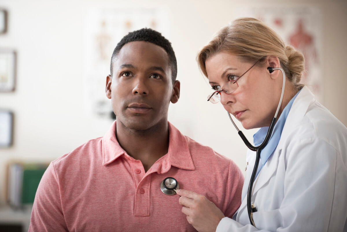 Doctor listening to heartbeat of patient in clinic