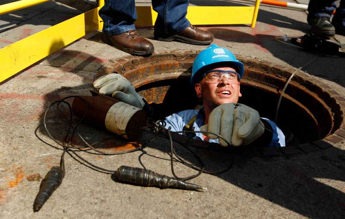 A Con Edison worker attempts to locate the source of a power outage in New York