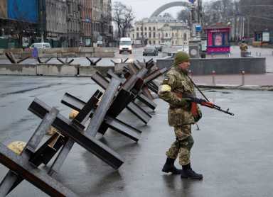 A member of the Territorial Defence Forces guards a checkpoint in central Kyiv