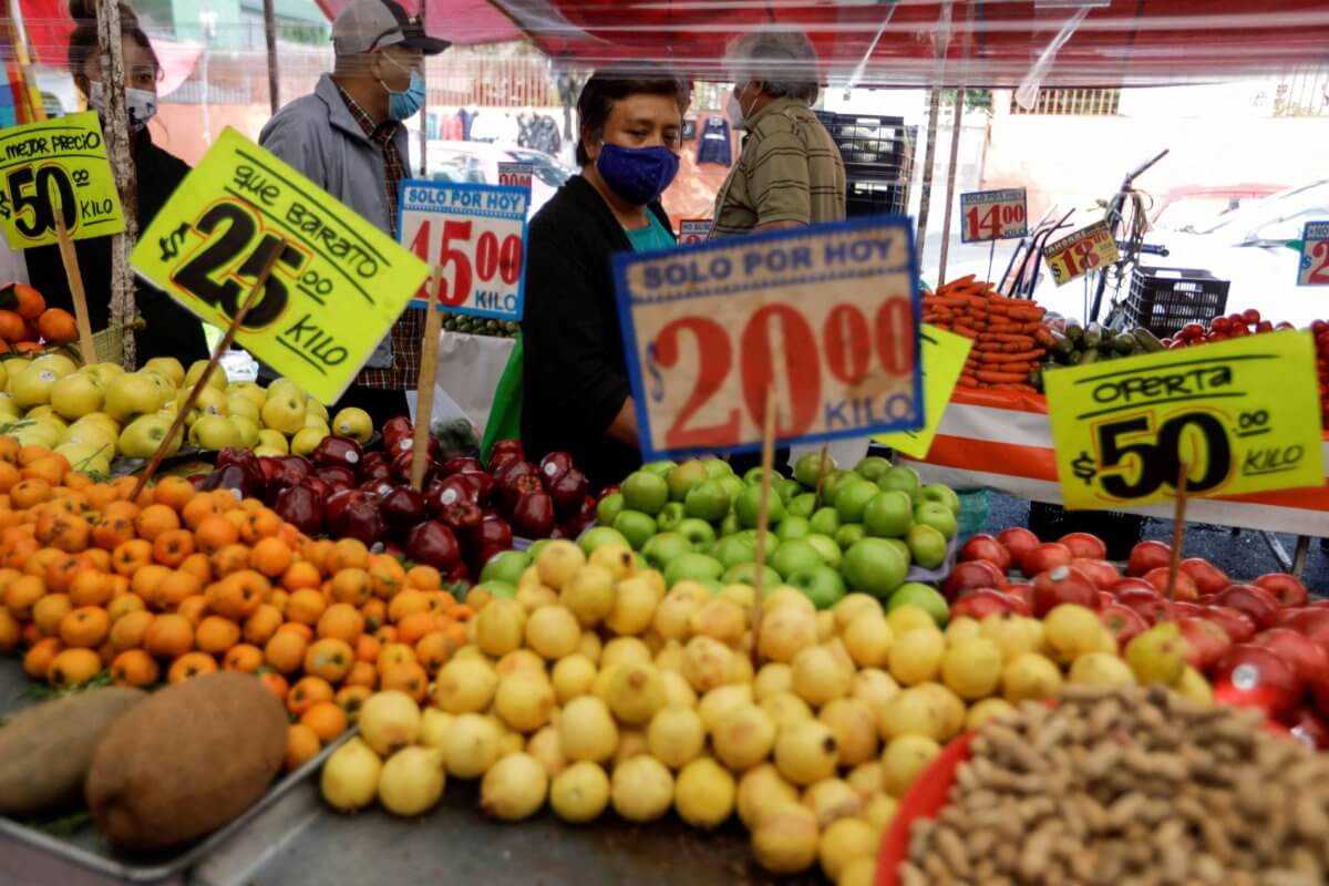 FILE PHOTO: Customers walk past a fruit stall at a street market, in Mexico City