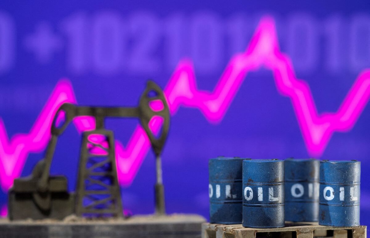 FILE PHOTO: Models of oil barrels and a pump jack are displayed in front of a rising stock graph and “$100” in this illustration