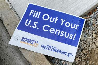 FILE PHOTO: A sign encouraging participation in the U.S. Census lies on a sidewalk in Somerville