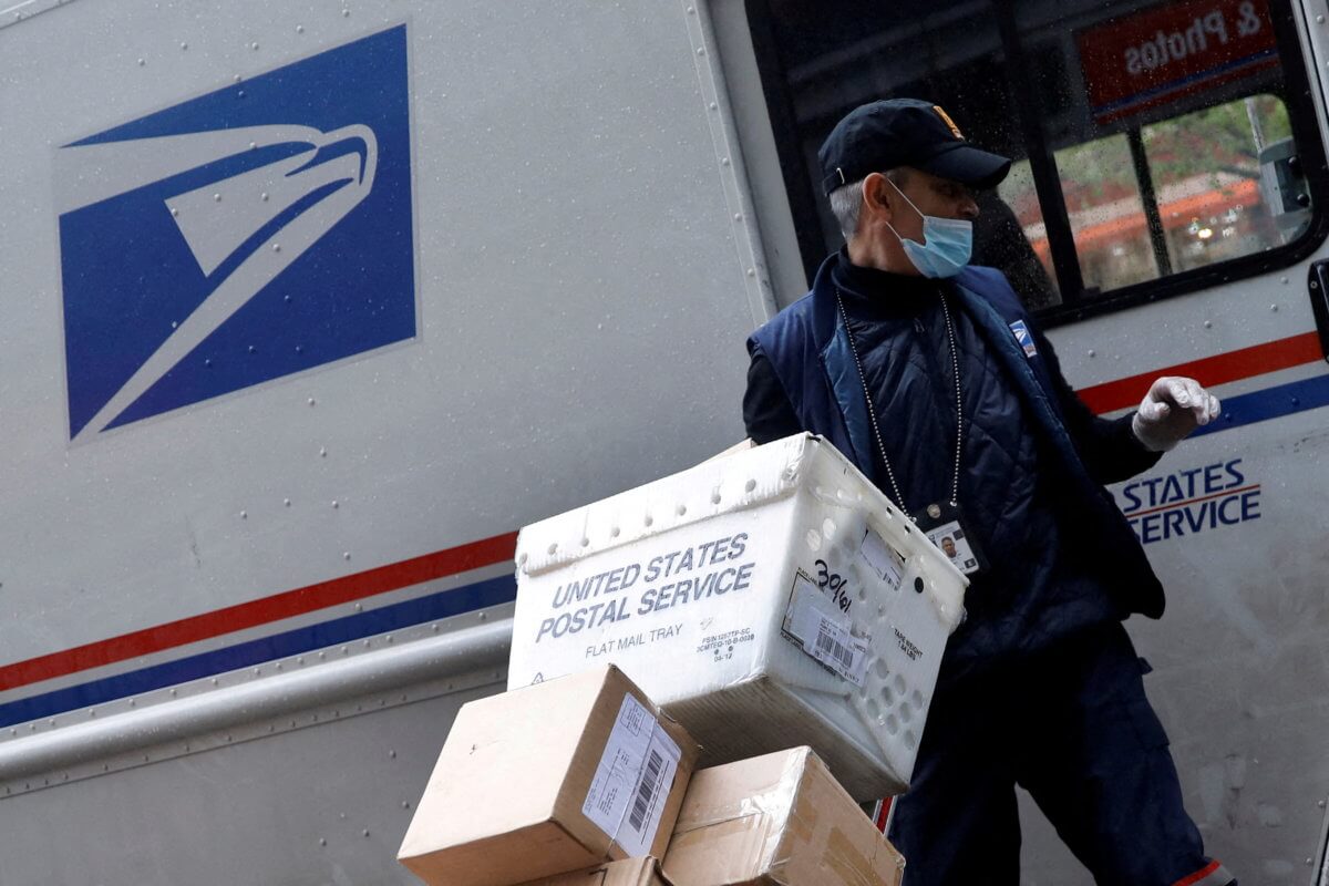 FILE PHOTO: United States Postal Service (USPS) worker unloads packages in Manhattan during outbreak of coronavirus disease (COVID-19) in York
