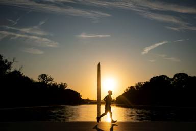 FILE PHOTO: A man runs near the reflecting pool between the Lincoln Memorial and the Washington Monument at sunrise on the National Mall in Washington