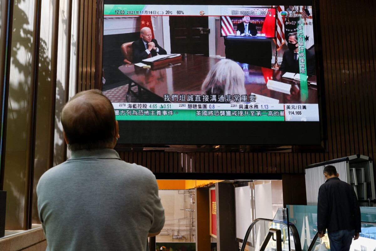 FILE PHOTO: A TV screen shows news of a video meeting between U.S. President Joe Biden and Chinese President Xi Jinping, in Hong Kong