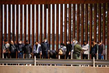 FILE PHOTO: Asylum-seeking migrants are detained by a U.S. Border Patrol agent after crossing the Rio Bravo river to turn themselves in to request asylum in El Paso, Texas, U.S., as seen from Ciudad Juarez