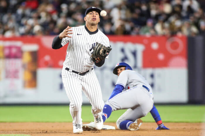 Yankees second baseman Gleyber Torres is unable to hold onto the ball, allowing Toronto Blue Jays second baseman Santiago Espinal to steal second base in the fifth inning.