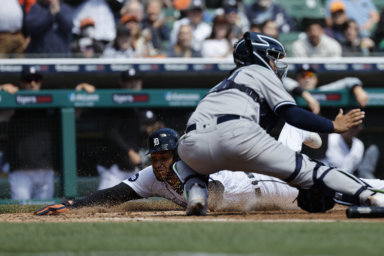 Tigers right fielder Victor Reyes dives in safe at home ahead of the tag by Yankees catcher Jose Trevino in the 3rd inning of the shutout game.