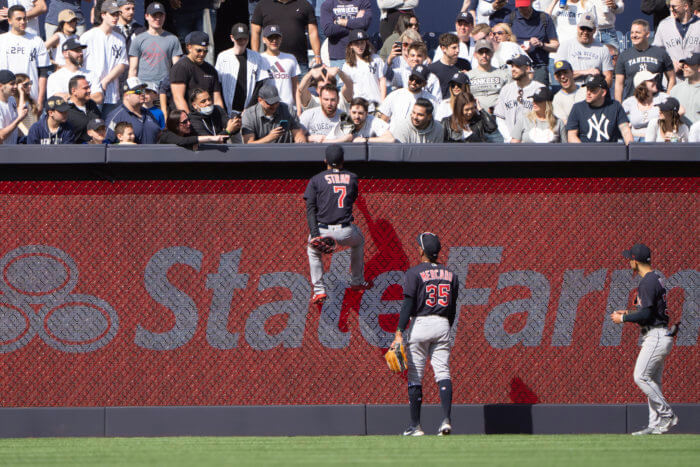 Cleveland Guardians center fielder Myles Straw climbs the fence to go after fans after they began throwing objects onto the field following the Yankees walk-off win in the Bronx.