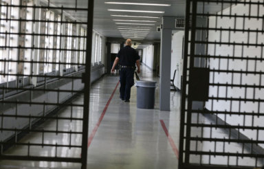 A Rikers Island juvenile detention facility officer walks down a hallway of the jail