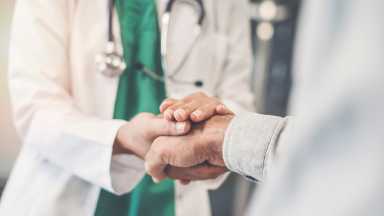 Health worker holding patient’s hand