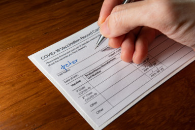 Writing a name on a Covid-19 vaccination record card
