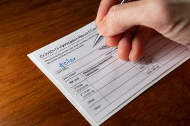 Writing a name on a Covid-19 vaccination record card