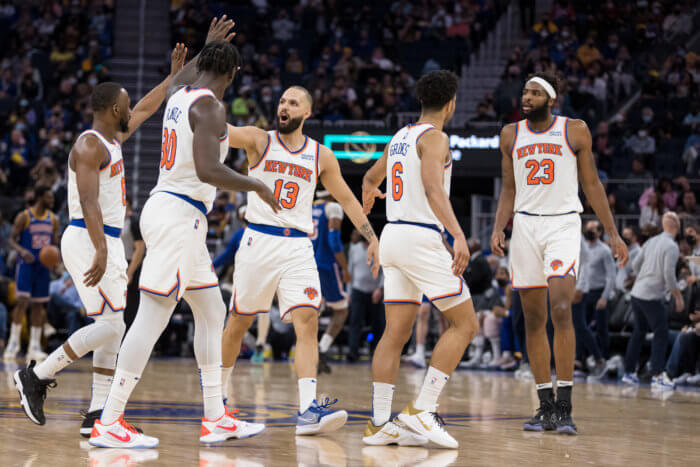 Knicks guard Evan Fournier celebrates with guard Kemba Walker and forward Julius Randle.