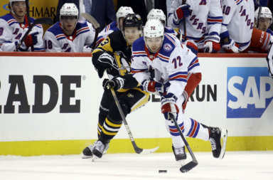 Rangers center Filip Chytil moves the puck against Pittsburgh Penguins left wing Danton Heinen.