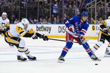 Pittsburgh Penguins center Evgeni Malkin attempts to steal the puck from Rangers center Andrew Copp.