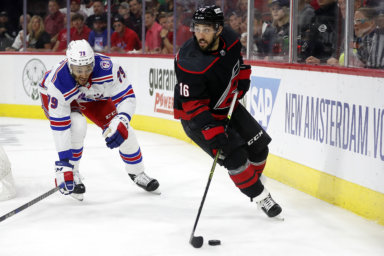 Hurricanes' Vincent Trocheck controls the puck in front of Rangers' K'Andre Miller during the second period of Game 1.