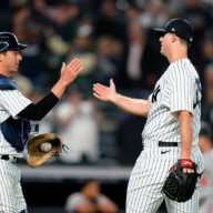 Yankees catcher Kyle Higashioka, left, celebrates with relief pitcher Clay Holmes after the team's 2-0 win.