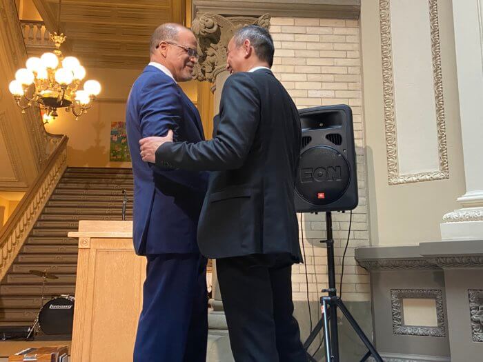 Chancellor Banks and Lucius Young embrace before a DOE announcement for AAPI curriculum.